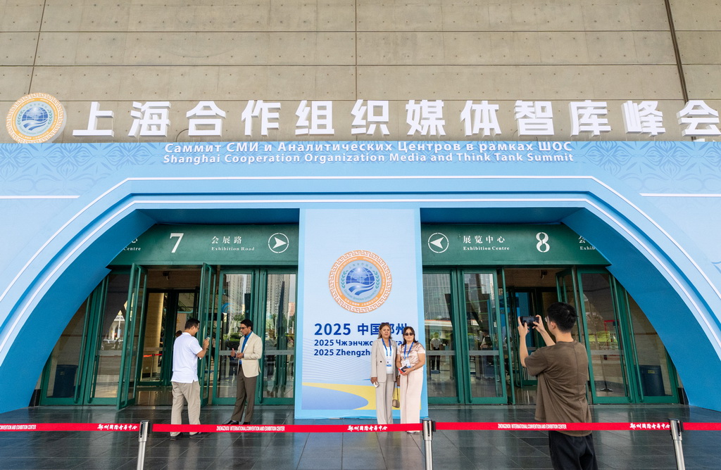 7月24日，在河南郑州举行的上海合作组织媒体智库峰会会场外，与会代表合影留念。新华社记者 伍婧丹 摄