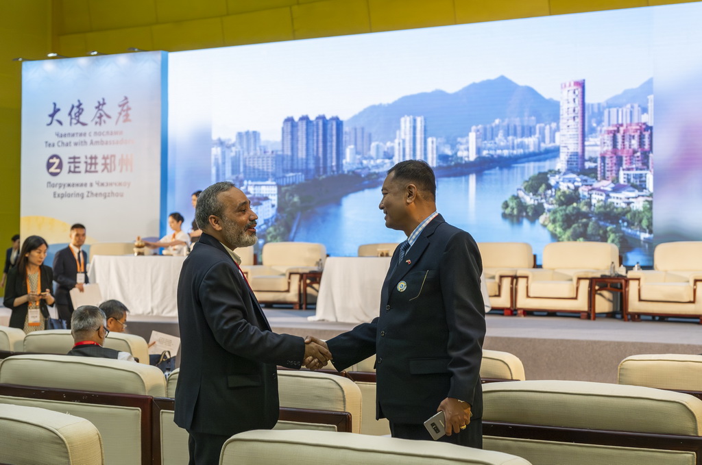 7月24日，在河南郑州举行的上海合作组织媒体智库峰会会场，与会代表握手寒暄。新华社记者 傅天 摄