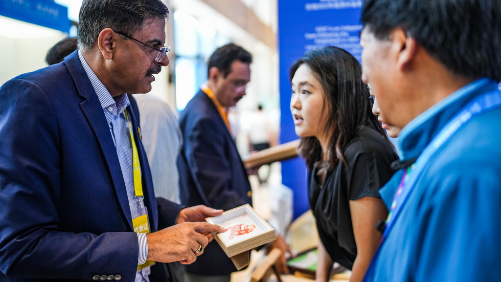 7月26日，参会代表参观非遗手工作品。