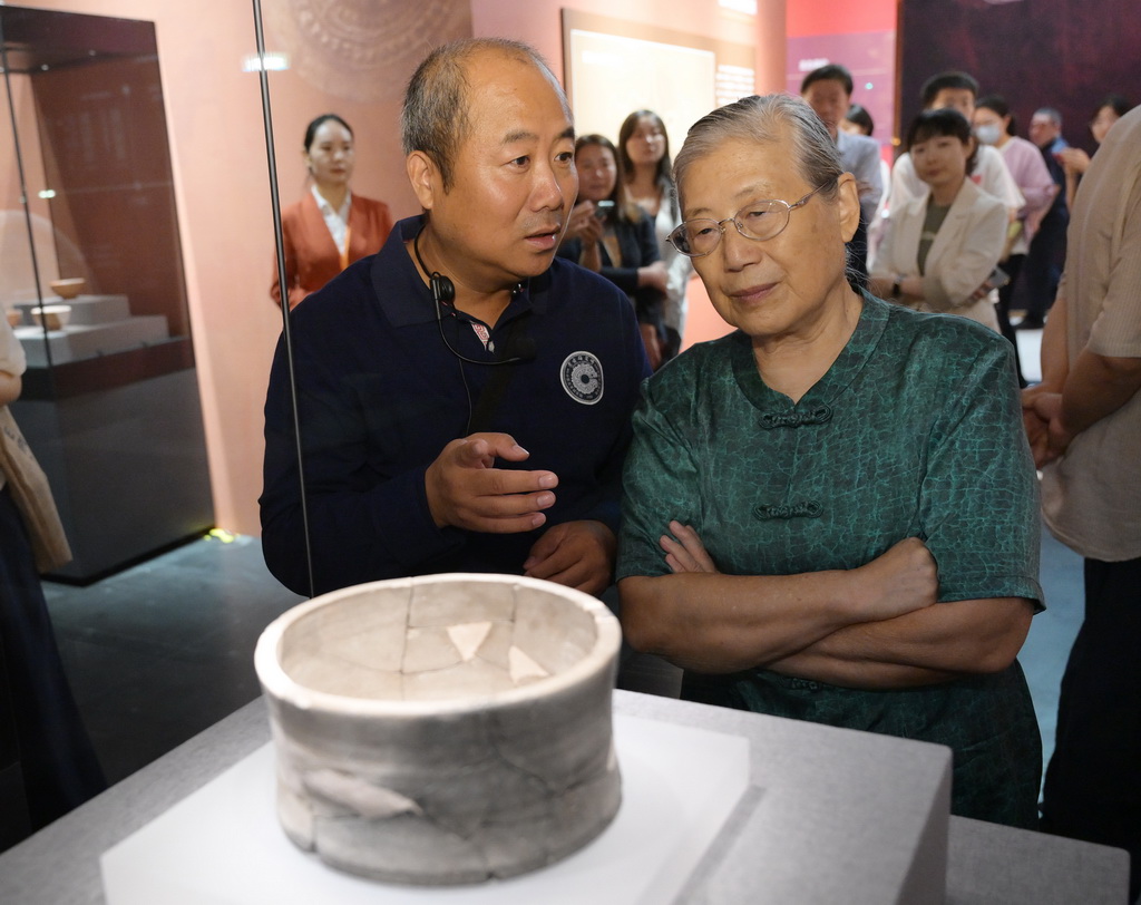 7月28日，著名考古学家、中国社会科学院考古研究所研究员安家瑶（右）在雄安新区联合考古队领队何岁利的陪同下参观展览。
