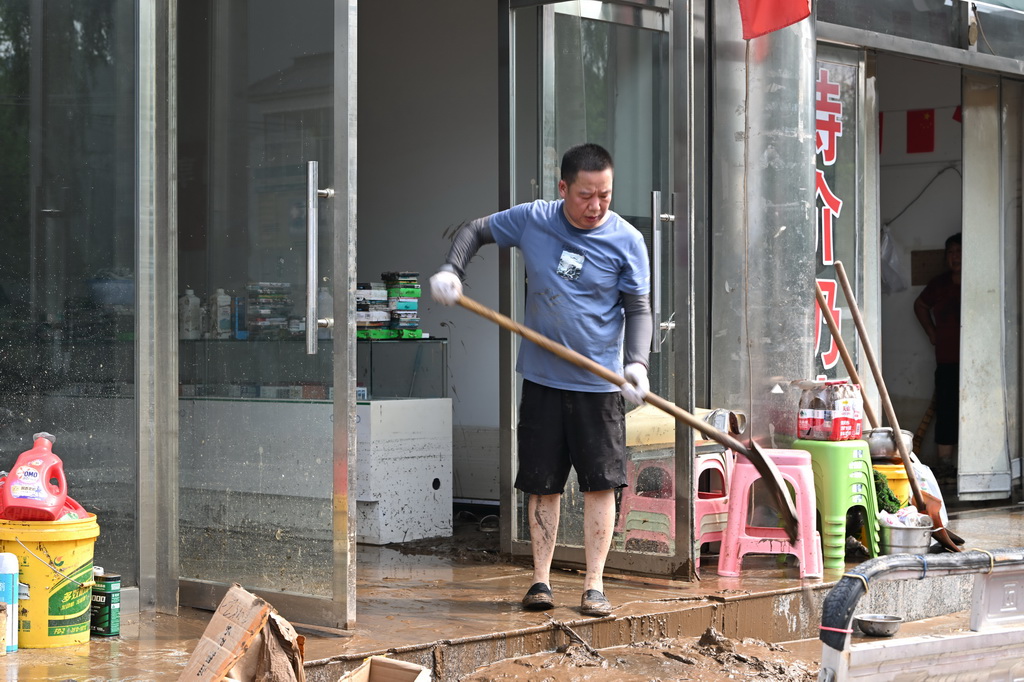 7月28日，居民在天津市蓟州区下营镇下营村清理屋内的淤泥。