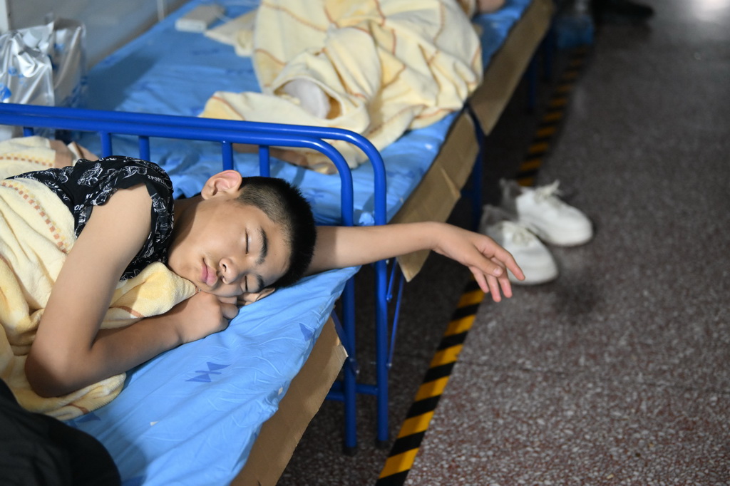 7月29日，一名小朋友在天津市蓟州区下营镇初级中学睡觉。