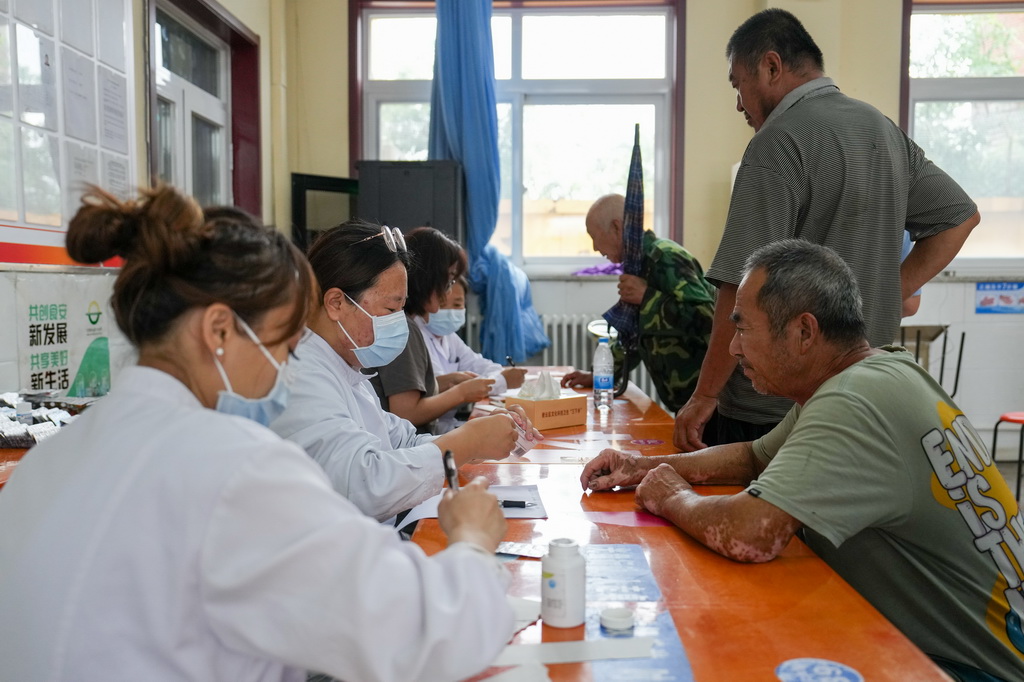 7月29日，在北京市密云区太师庄中学居民安置点，太师屯镇社区卫生服务中心的医生为安置在此的群众开药。