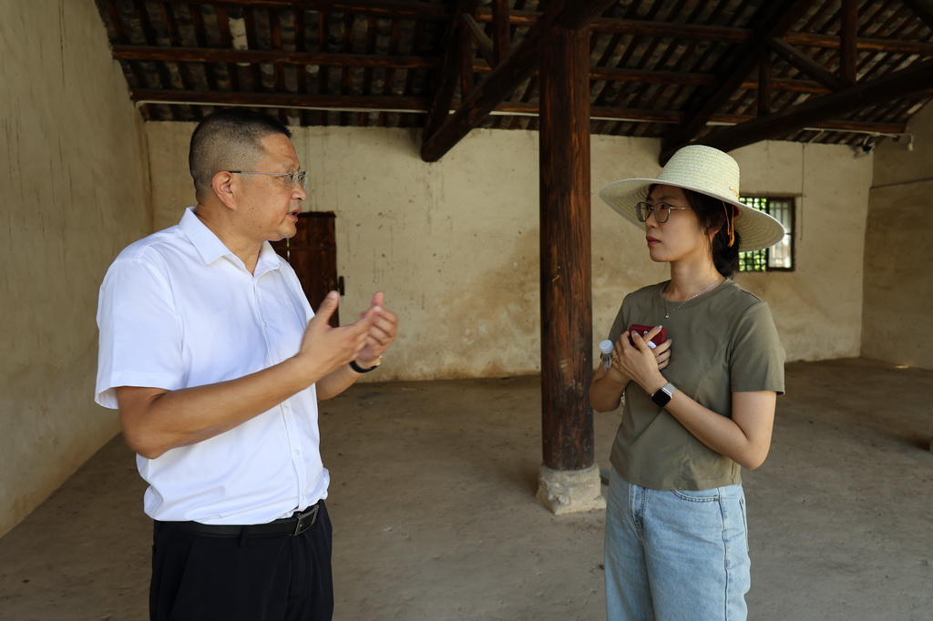 大悟县革命传统教育基地管理委员会副主任付波（左）在新四军第五师国际招待所内向记者讲述历史（7月21日摄）。新华社记者 朱唯希 摄