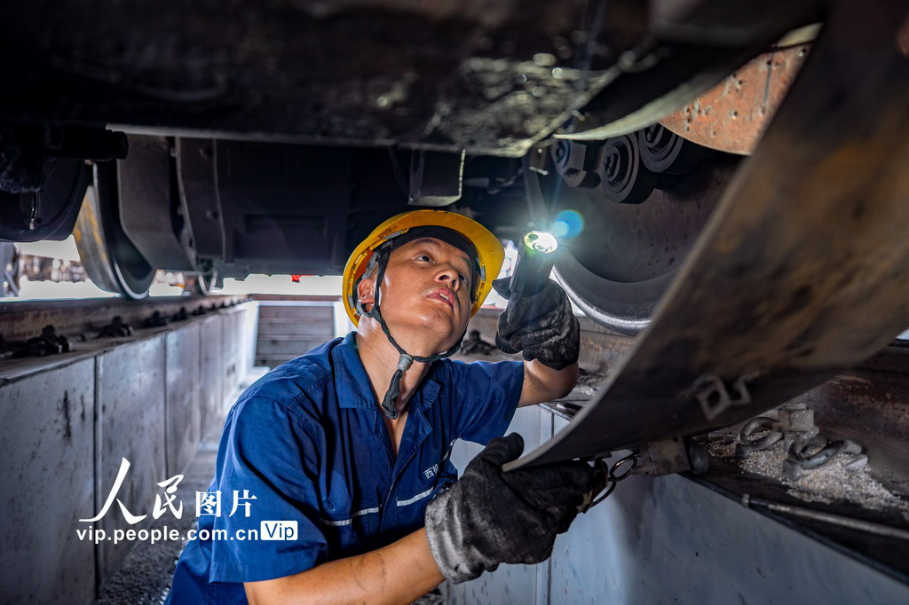 8月4日，西安机务段机车整备场，该段职工正在检查机车走行部状态。