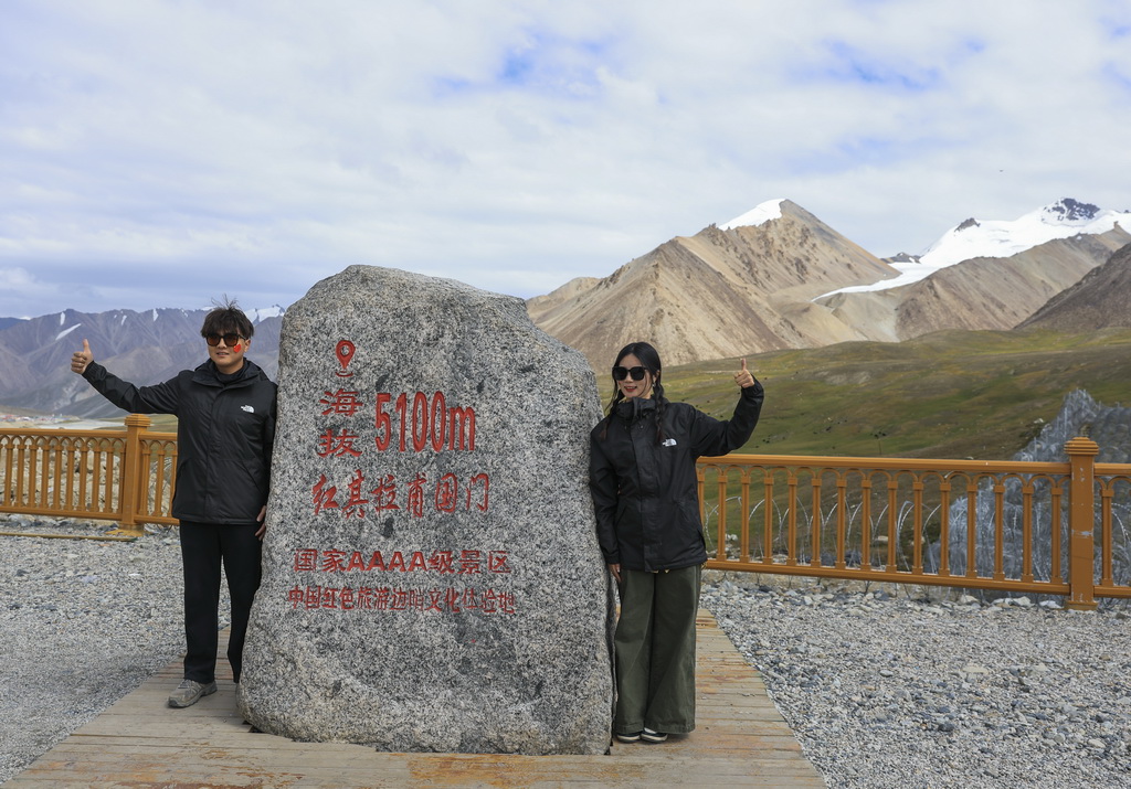 8月2日，游客在位于新疆塔什库尔干塔吉克自治县的中巴边境红其拉甫口岸拍照留念。