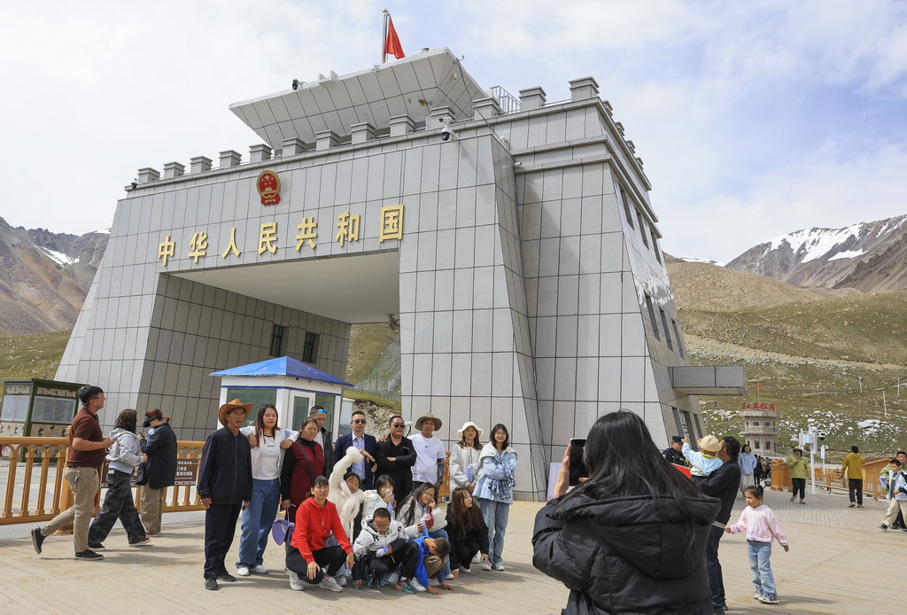8月2日，游客在位于新疆塔什库尔干塔吉克自治县的中巴边境红其拉甫口岸拍照留念。