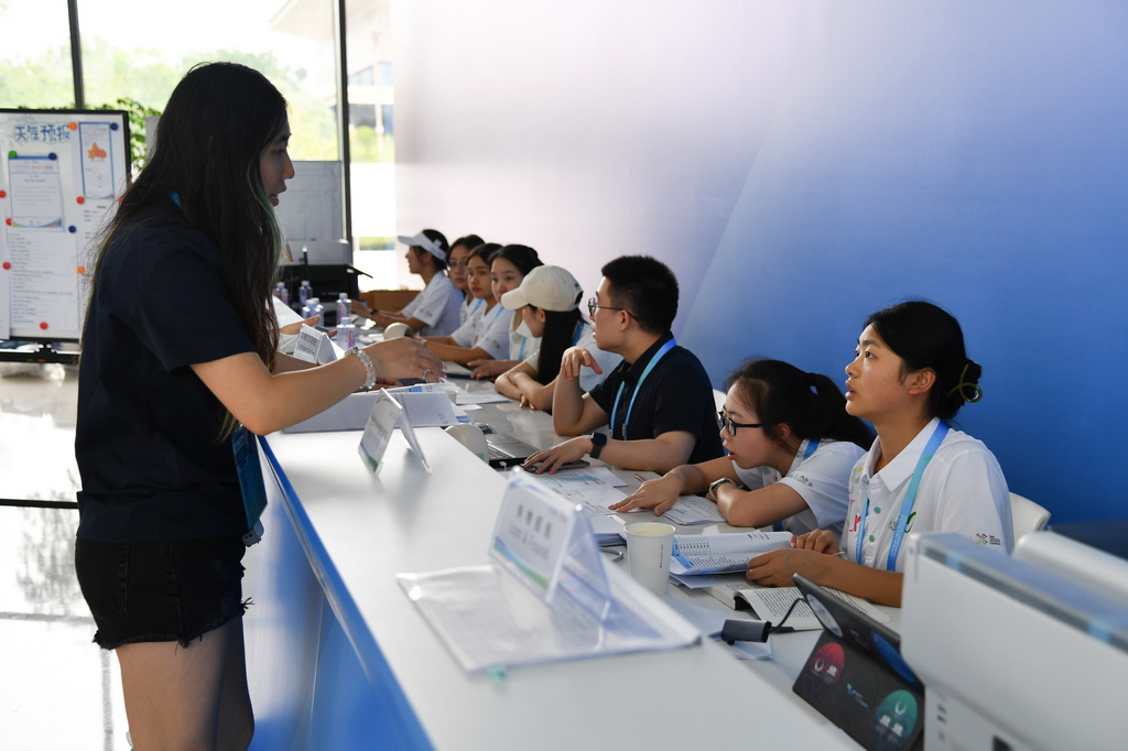 8月4日，志愿者（右一）在成都世运会主媒体中心提供信息咨询服务。新华社记者 张博文 摄