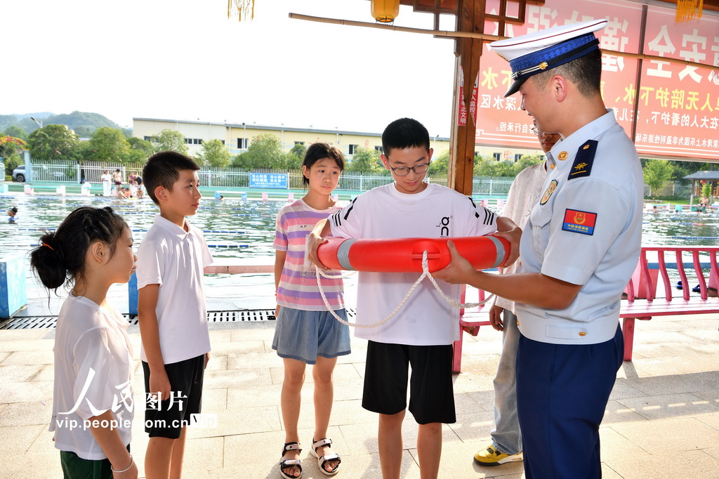 8月5日，消防员为学生讲解救生圈的使用方法。
