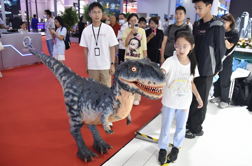 8月8日，观众在2025世界机器人大会现场与展出的仿真恐龙互动。新华社记者 李欣 摄