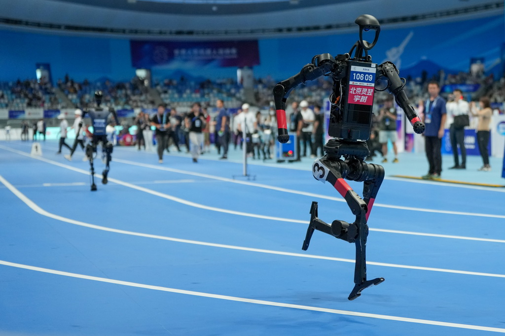 8月17日，在世界人形机器人运动会4x100米接力决赛中，来自灵翌科技队的人形机器人（前）在比赛中。