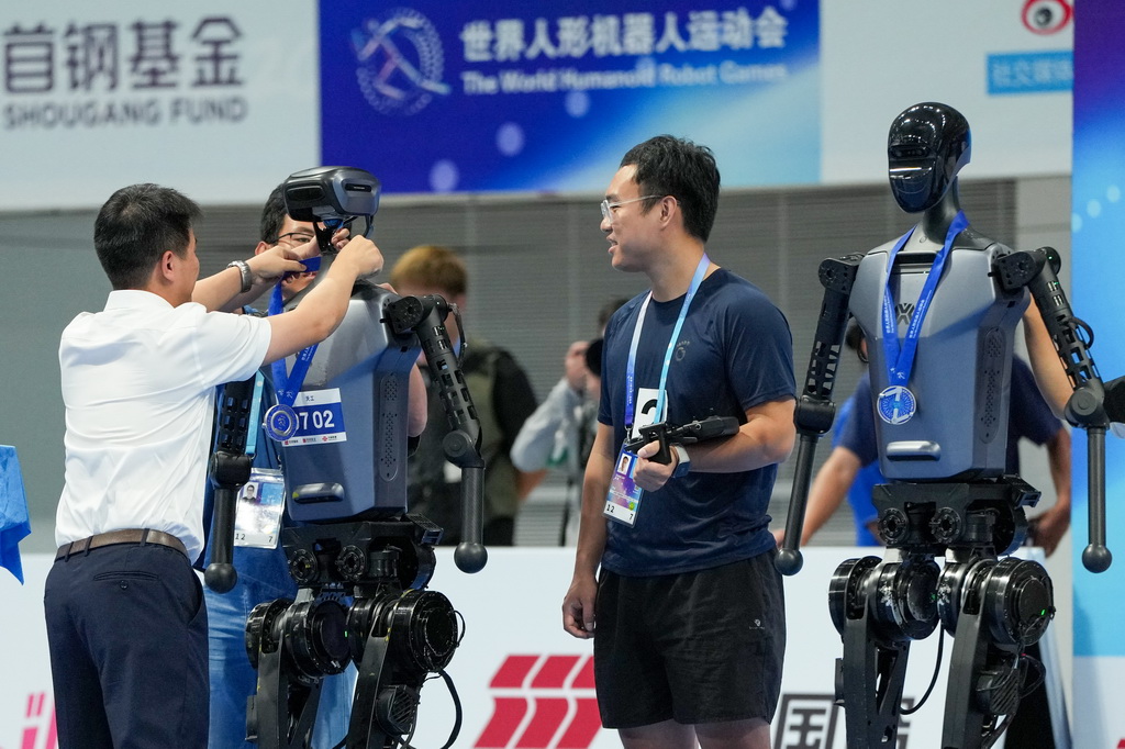 8月17日，颁奖嘉宾在4x100米接力决赛颁奖仪式上为获得亚军的天工队的人形机器人颁发奖牌。