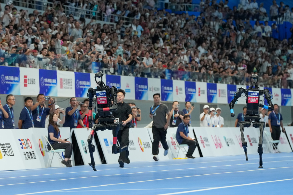 8月17日，在世界人形机器人运动会100米决赛中，来自高羿科技队（右）和灵翌科技队（左）的人形机器人在比赛中。