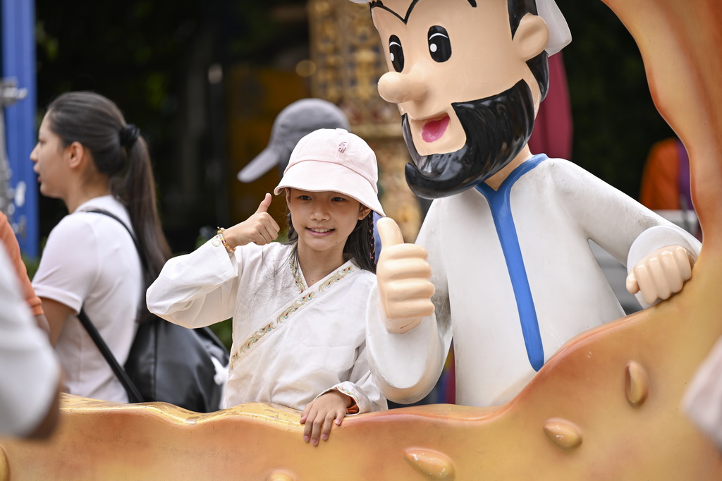 8月21日，小游客在乌鲁木齐大巴扎步行街拍照留影。