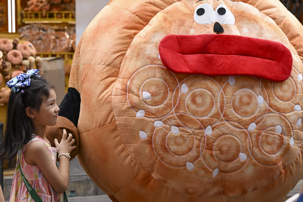 8月21日，一名小朋友在乌鲁木齐大巴扎步行街游玩。