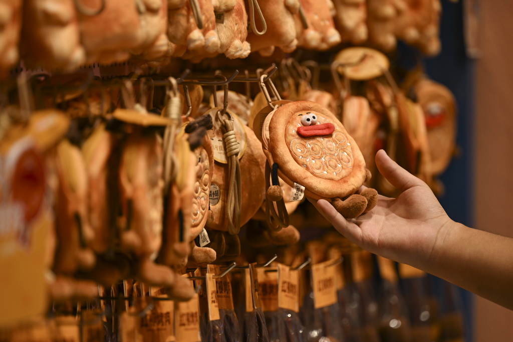 8月21日，游客在乌鲁木齐大巴扎步行街选购文创产品。