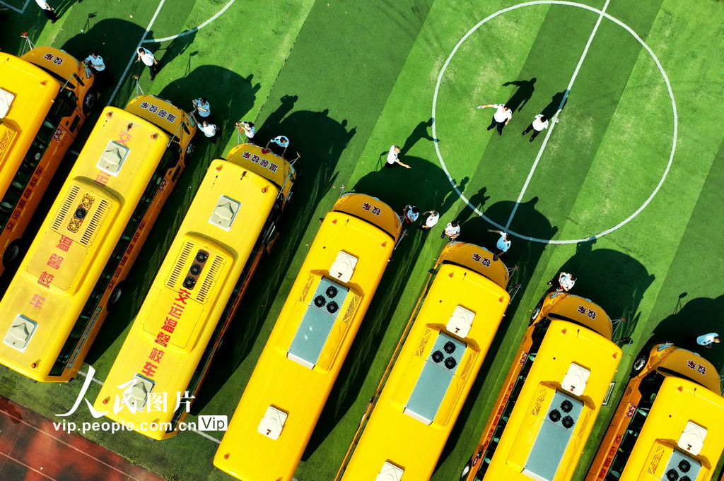 2025年8月22日，在山东省青岛市城阳区上马街道教育服务中心，技术人员和驾驶员在对校车进行维护。