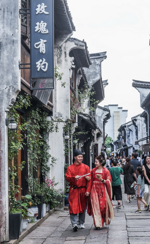 8月26日,在嘉兴市南湖区月河历史街区,游客身着传统服饰在古巷中拍摄写真。
