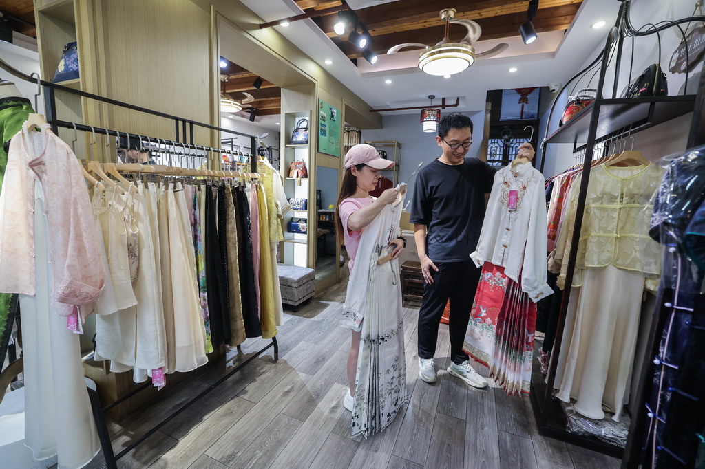 8月26日，游客在嘉兴市南湖区月河历史街区的一家店里挑选传统服饰。