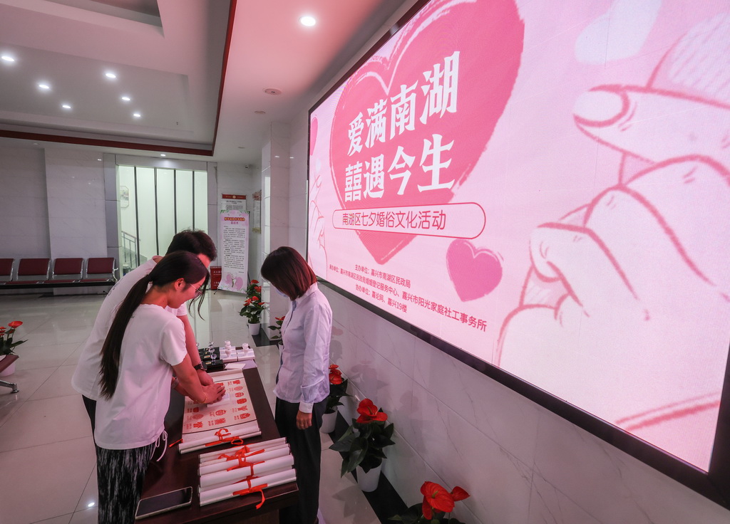 8月26日,一对新婚夫妻在嘉兴市南湖区民政局婚姻登记服务中心参加七夕婚俗文化活动。