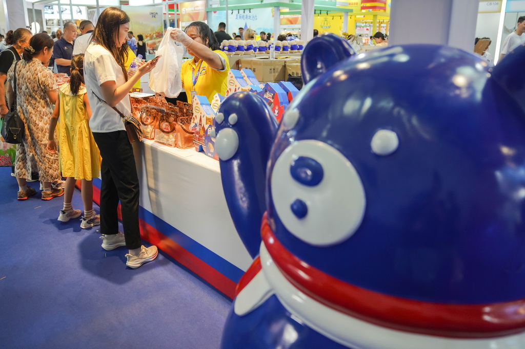 8月27日，游客在第十五届中国－东北亚博览会国际及港澳台特色商品馆内选购俄罗斯特色商品。新华社记者 许畅 摄