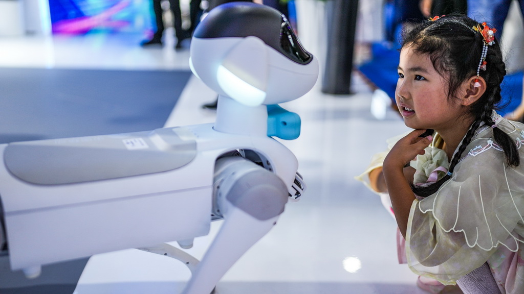 8月28日,小朋友在数博会上观看机器狗。新华社记者 陶亮 摄