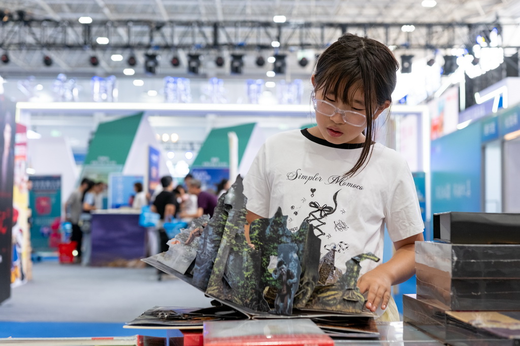 8月31日，读者在内蒙古呼和浩特市2025北疆书展阅读立体书。
