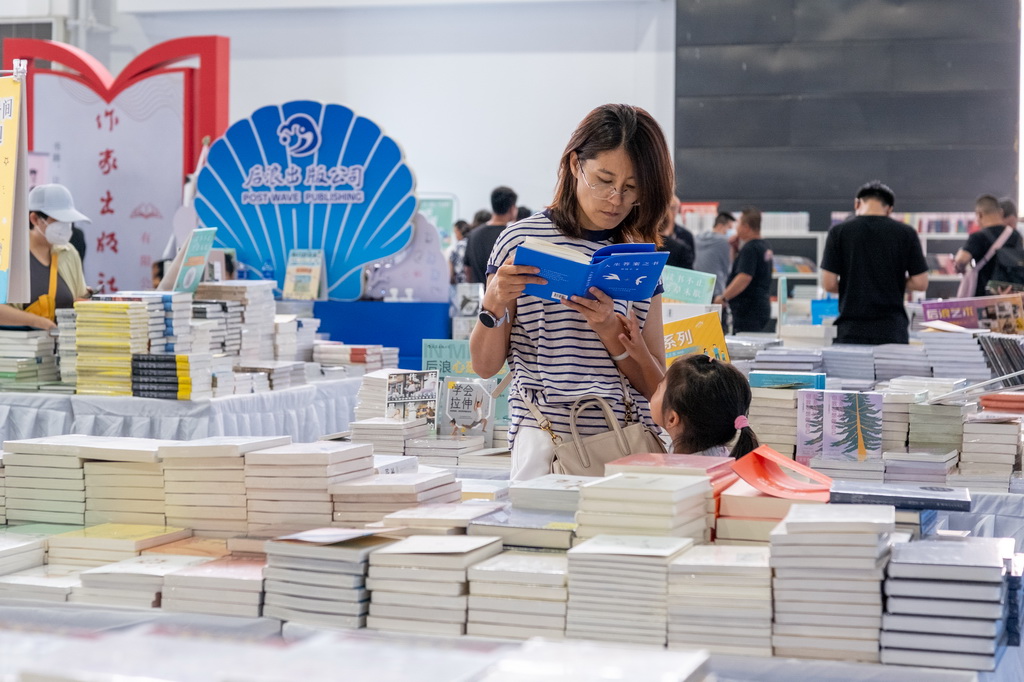 8月31日,读者在内蒙古呼和浩特市2025北疆书展阅读书籍。