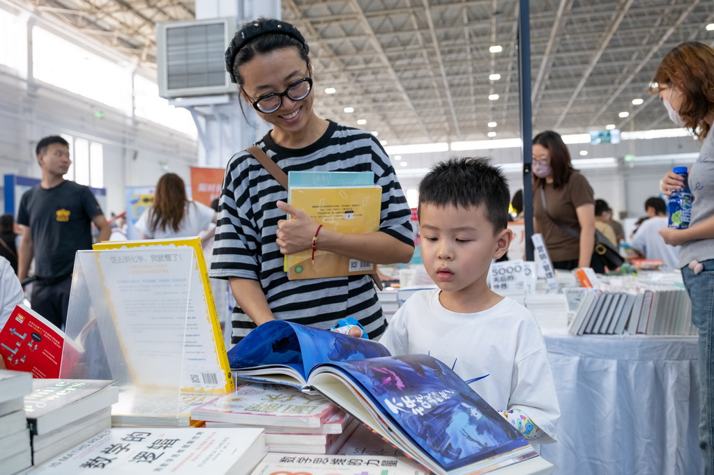 8月31日，小朋友在内蒙古呼和浩特市2025北疆书展阅读书籍。