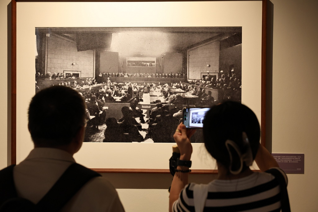 9月1日,参观者在艺术展上展出的抗战主题摄影作品前驻足观看。