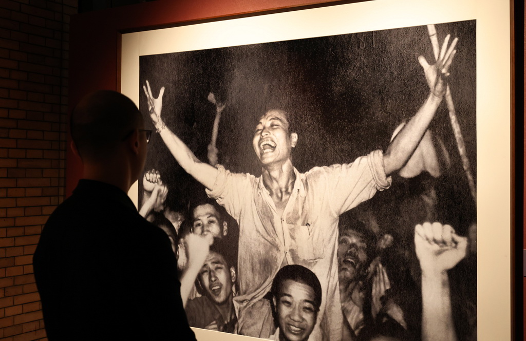 9月1日,参观者在艺术展上展出的摄影作品前驻足观看。