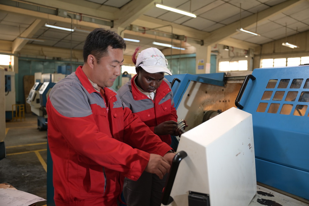 8月29日,在位于肯尼亚首都内罗毕的肯尼亚科技大学,中方指导老师与第十届非洲职业技能挑战赛的参赛选手在数控车床前交流。新华社记者 杨光 摄