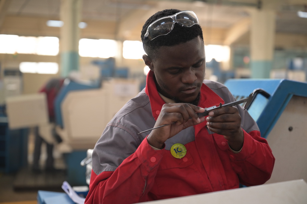 8月29日,在位于肯尼亚首都内罗毕的肯尼亚科技大学,一名第十届非洲职业技能挑战赛的参赛选手在数控机床前检查游标卡尺。新华社记者 杨光 摄