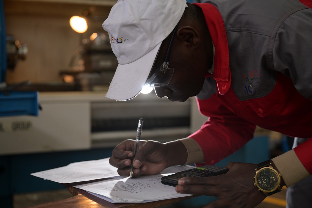 8月29日,在位于肯尼亚首都内罗毕的肯尼亚科技大学,一名第十届非洲职业技能挑战赛的参赛选手在数控机床前进行计算。新华社记者 杨光 摄