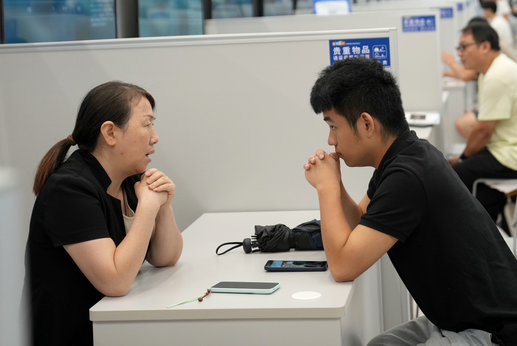 9月4日，一名求职者（右）与招聘企业代表在杭州市综合性人才招聘会上洽谈。