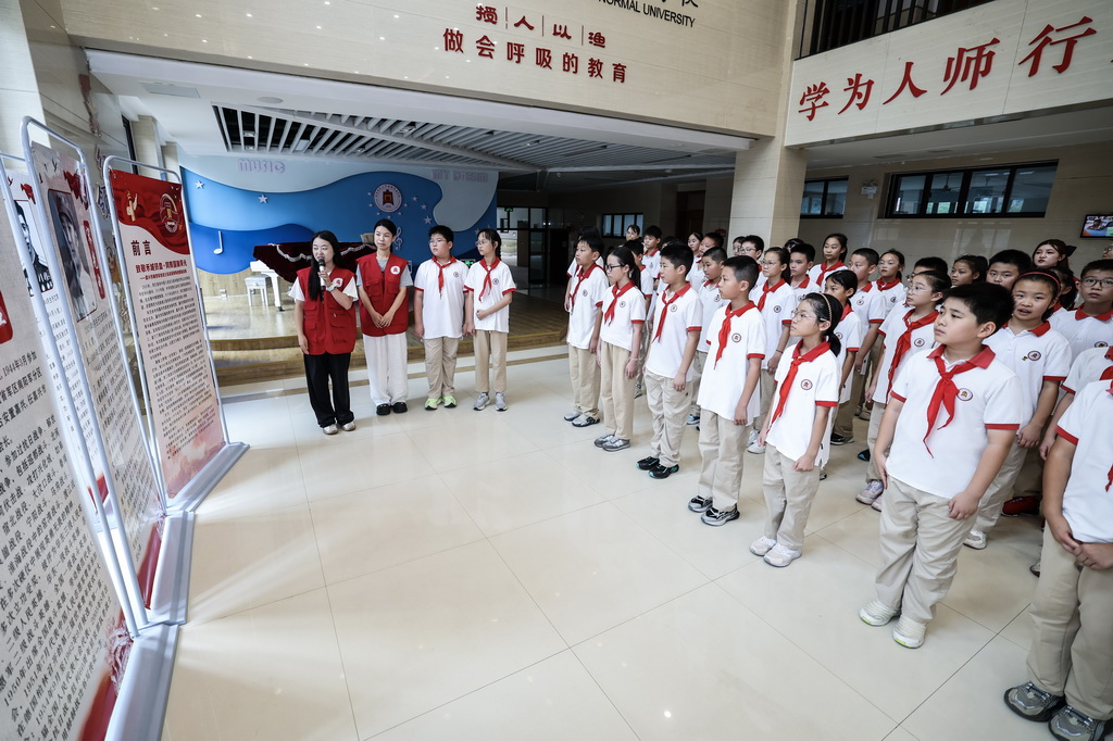 9月4日，北京师范大学南湖附属学校的老师在给学生们讲解“致敬禾城铁血·同辉国旗荣光”——嘉兴市新四军老战士抗战英勇事迹图版巡展的英雄事迹。
