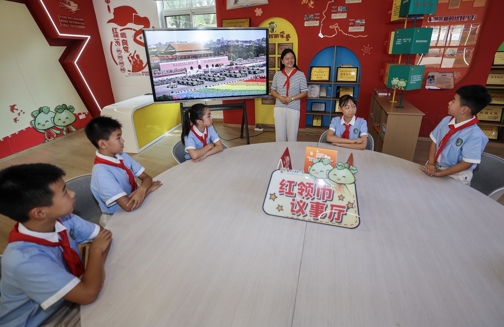 9月4日，嘉兴市实验小学的全国优秀辅导员陈伟凤老师（中）与学生们一起交流观看九三阅兵后的感受。