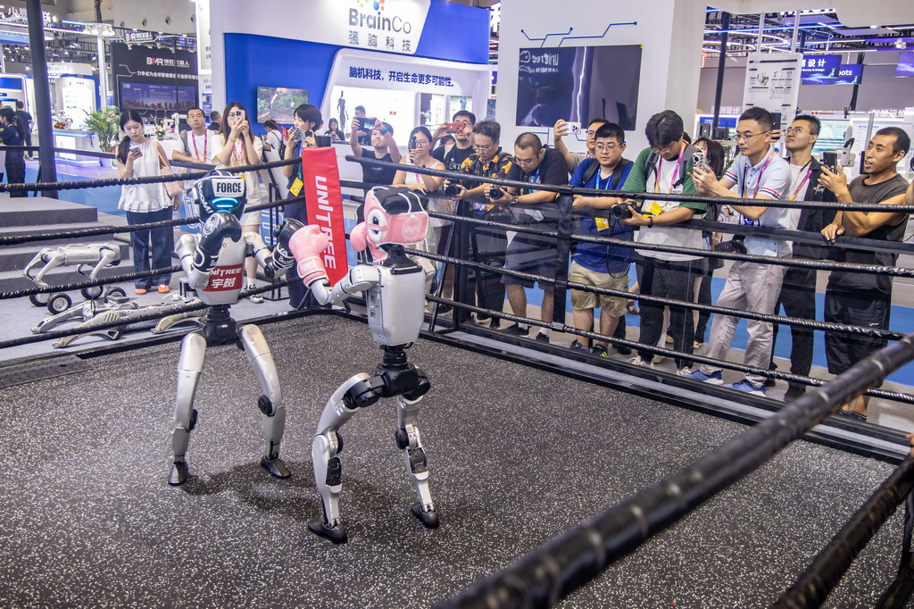9月4日，媒体记者和嘉宾在2025世界智能产业博览会宇树科技展厅观看机器人拳击赛。新华社记者 唐奕 摄