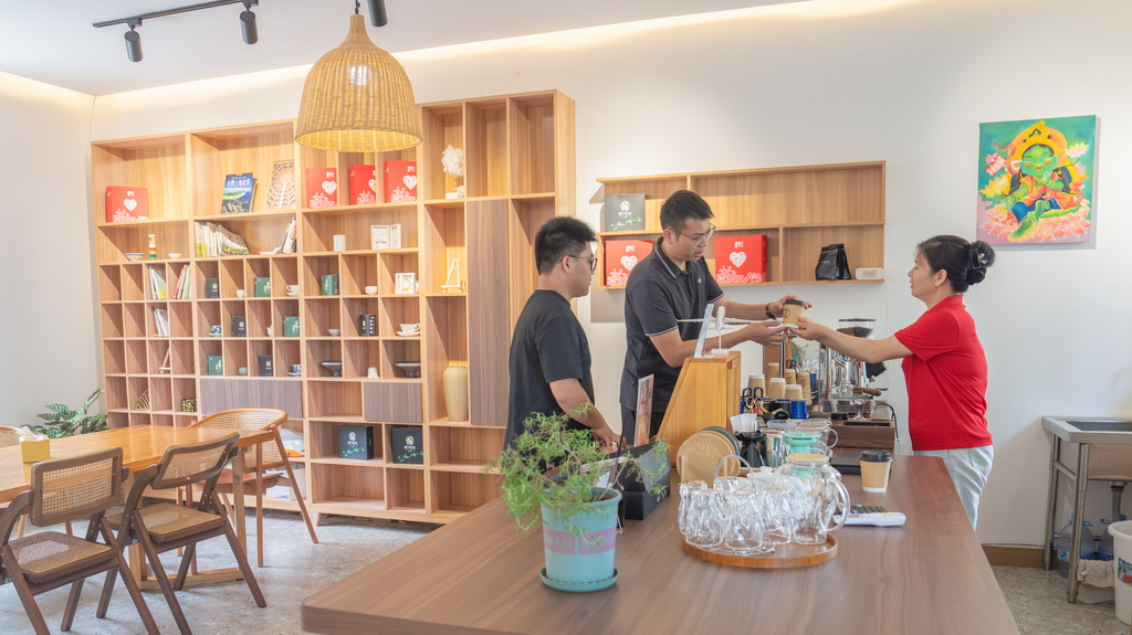 9月6日，游客在雄江镇小柒咖啡馆购买咖啡。