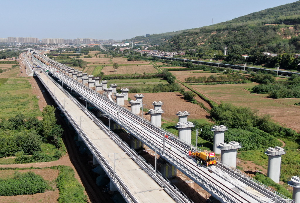 9月8日,施工车辆在西十高铁西安东至蓝田区间铺设无缝钢轨(无人机照片)。