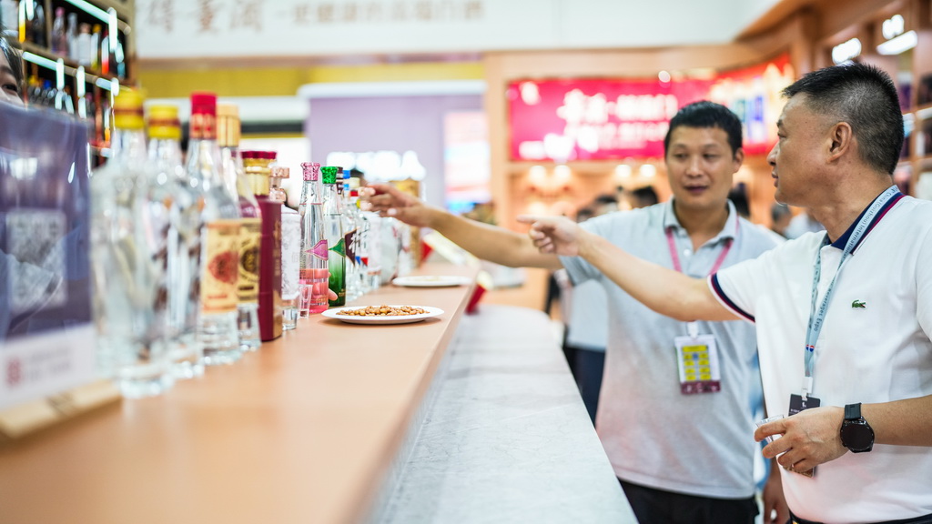 9月9日，参展商在酒博会现场了解酒类商品。