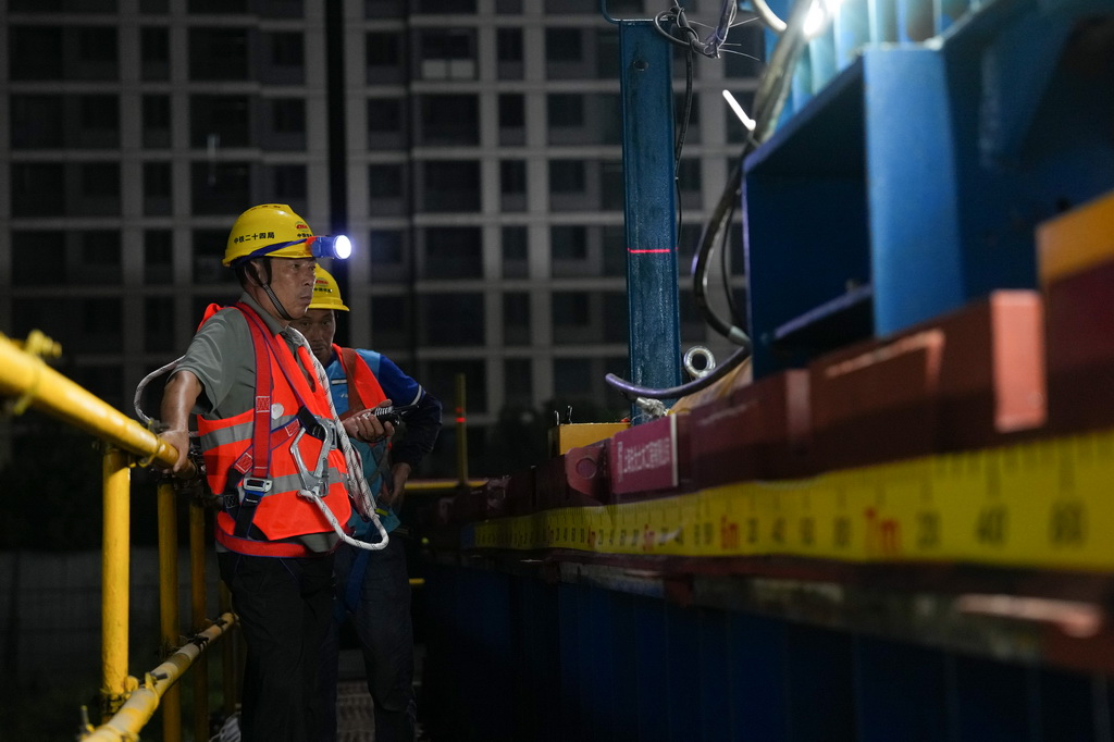 9月10日凌晨,工程技术人员在浙江绍兴城际铁路柯桥站顶推横移换梁施工现场关注设备运行情况。