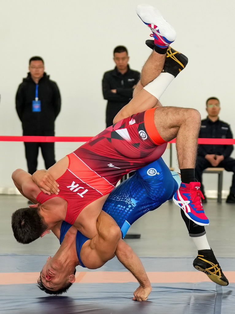 9月9日，塔吉克斯坦（红）与哈萨克斯坦的参赛队员在勇士摔跤比赛中。