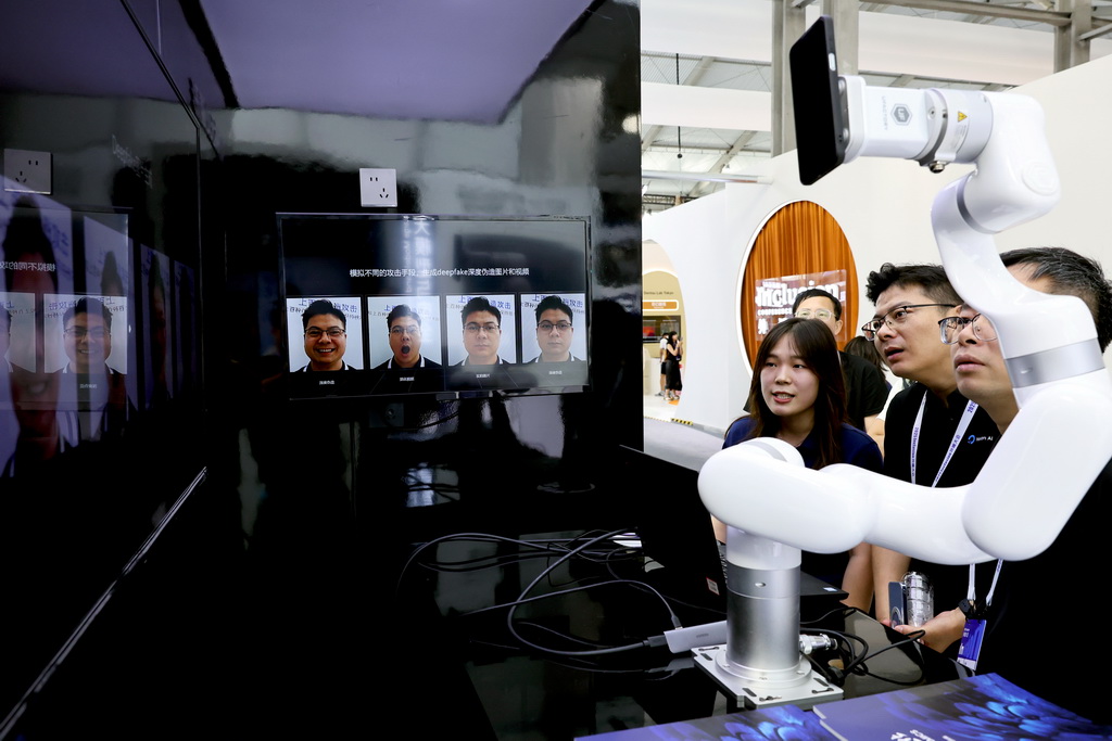 9月10日，参观者在一个甄别AI换脸技术的演示设备前驻足观看。