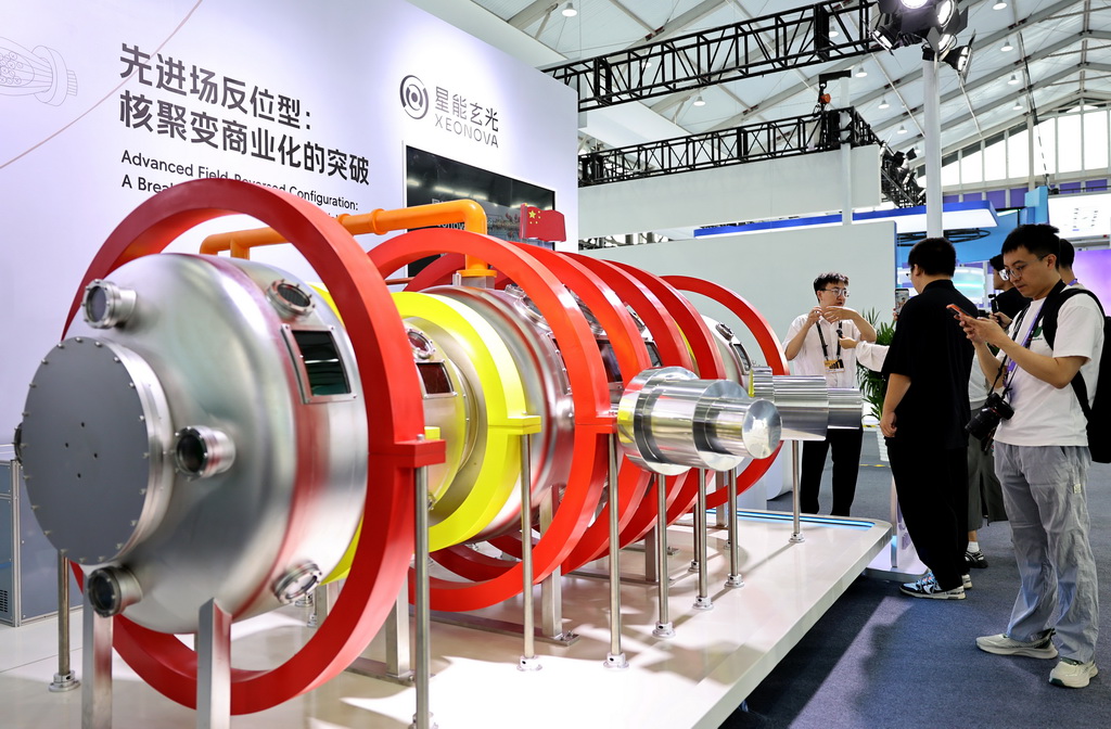 9月10日，参观者在一个先进场反位型装置模型前驻足观看。