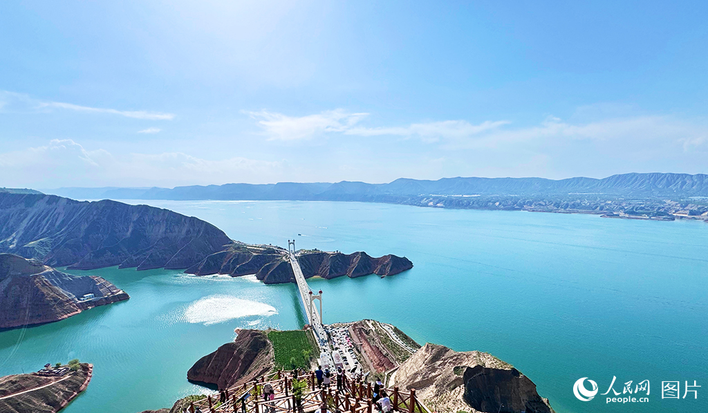 6月14日，甘肃省临夏回族自治州永靖县黄河段呈现出水色湛蓝、平静清澈的美丽景象。该区域汇集了大夏河、洮河等多条河流，并坐拥炳灵湖、太极湖和恐龙湖三大湖泊。近年来，永靖县重点推进水环境治理，通过对黄河两岸山体进行系统绿化，坡地逐步形成了以耐旱草本和灌木为主的完整植被生态系统，有效实现了水土保持。累计建成生态林24.73万亩、经济林9500亩，治理水土流失813平方公里。黄河临夏段成功入选全国第三批美丽河湖优秀案例，并赢得了“蓝色黄河”的美誉。人民网记者 焦隆摄