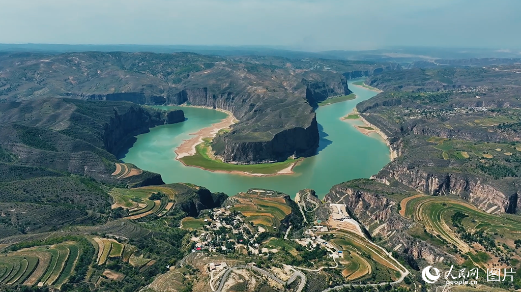 位于内蒙古呼和浩特市清水河县老牛湾镇的老牛湾黄河大峡谷，是黄河与长城唯一“握手”的地方，素有“天下黄河第一湾”的美誉。近年来，老牛湾镇积极践行“绿水青山就是金山银山”的发展理念，以创建国家5A级旅游景区作为乡村振兴工作的重要抓手，推进文旅融合高质量发展。优美独特的自然环境吸引了大量游客，今年“五一”峰值日客流量达2万人，如今，运营民宿、游船等已成为当地村民实打实的优势产业、特色产业、富民产业。人民网 孟佳澍摄