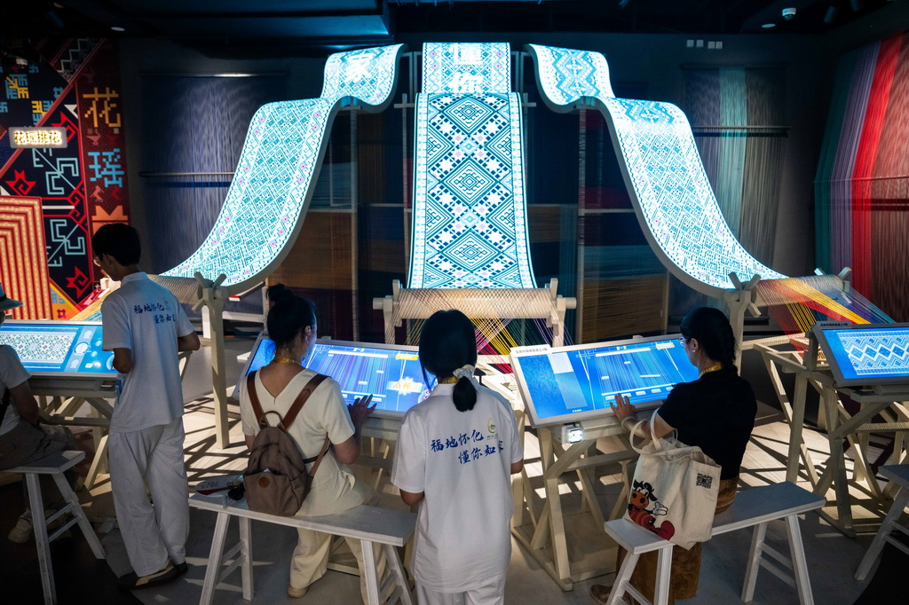 9月16日，在湖南省怀化市五溪非遗园，游客在体验数字化织锦。