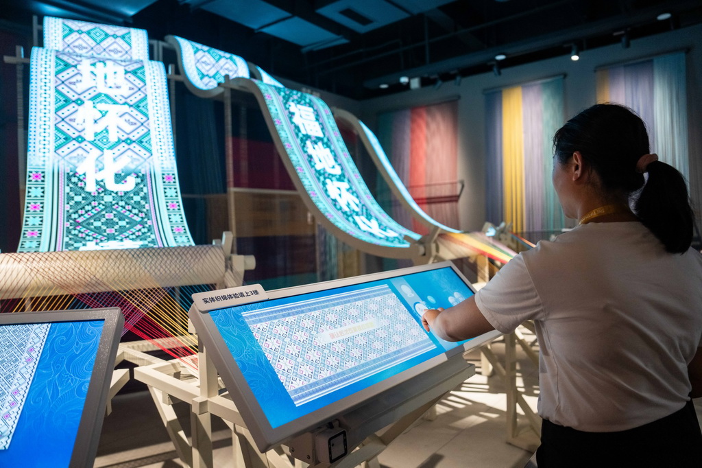 9月16日，在湖南省怀化市五溪非遗园，游客在体验数字化织锦。