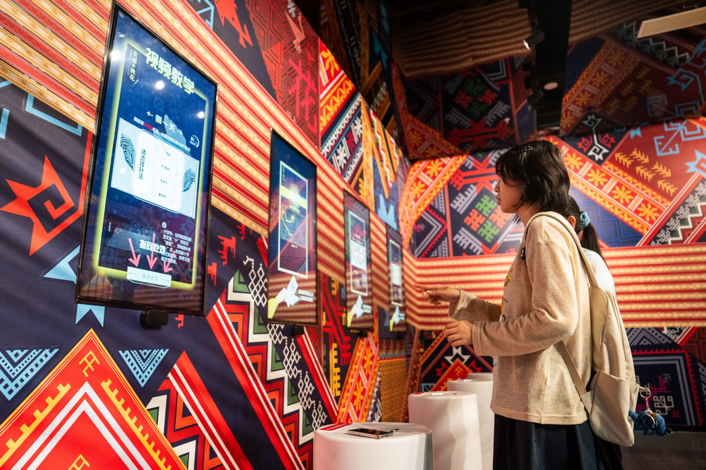 9月16日，在湖南省怀化市五溪非遗园，游客在体验数字化花瑶挑花。